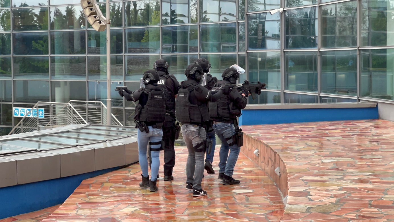 A group of people in black uniforms holding guns

Description automatically generated